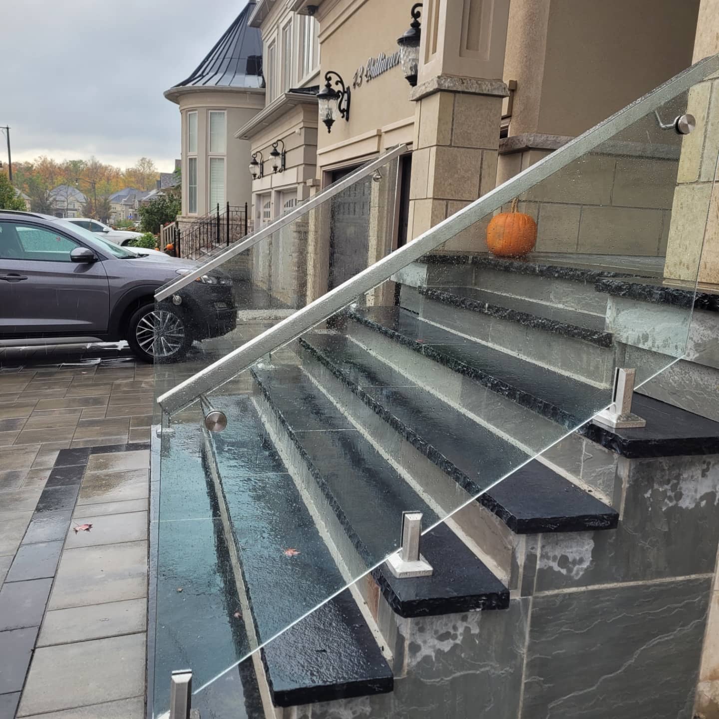 Frameless glass railing along exterior brick front steps