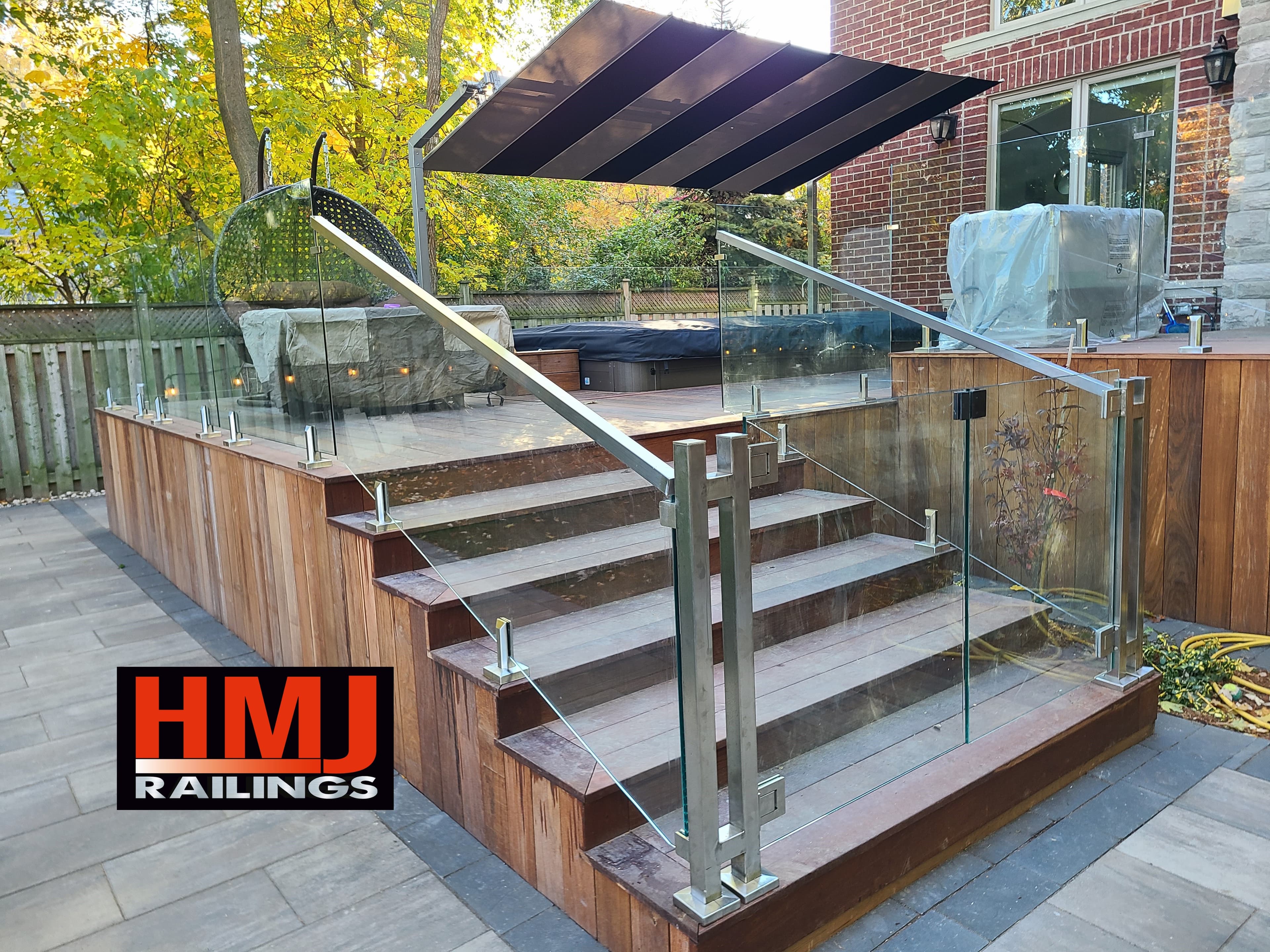 Frameless glass gate with stainless spigots on a residential walkway