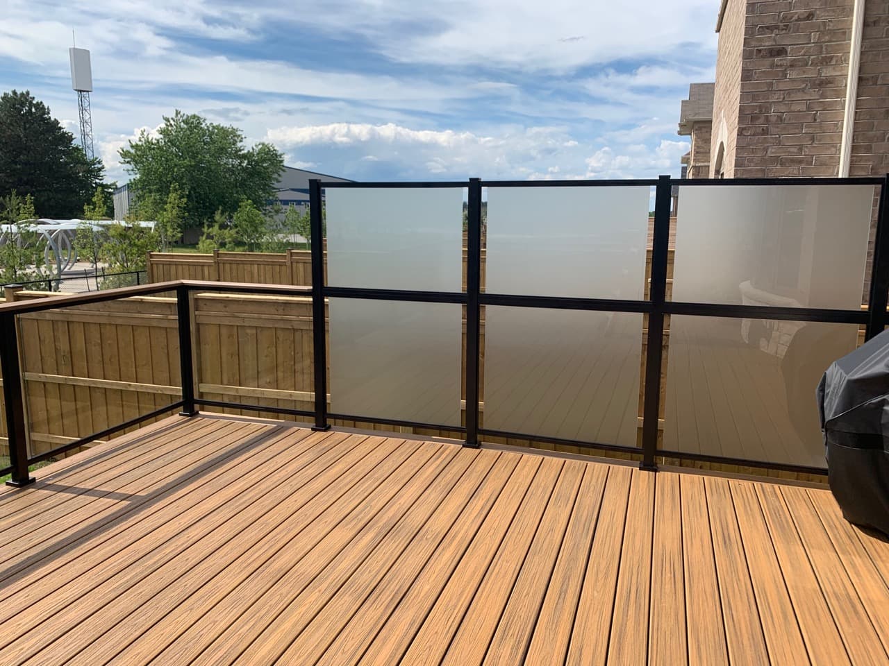 Frosted glass privacy panel on a backyard deck