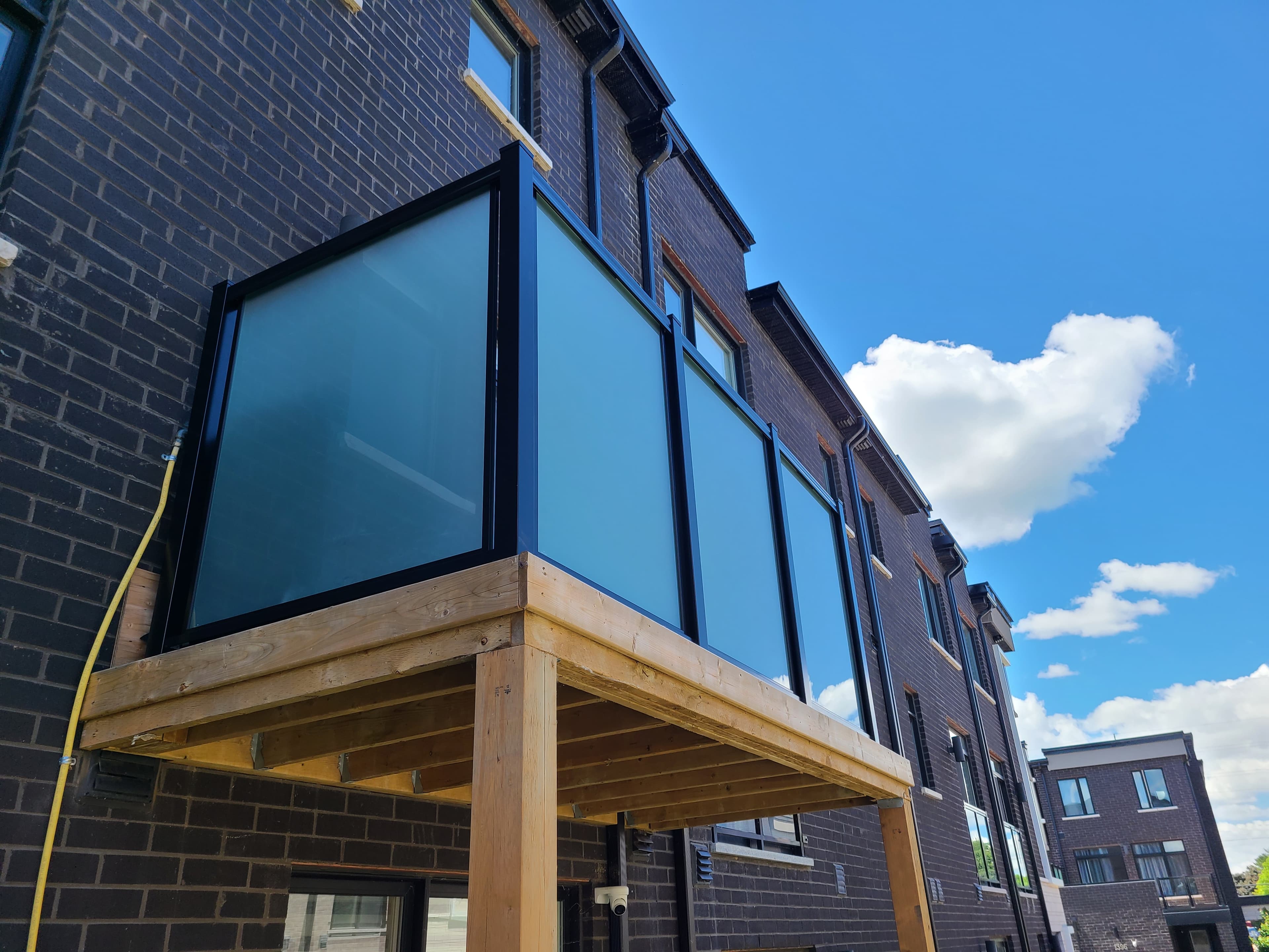 Frosted privacy glass panels on a modern deck extension